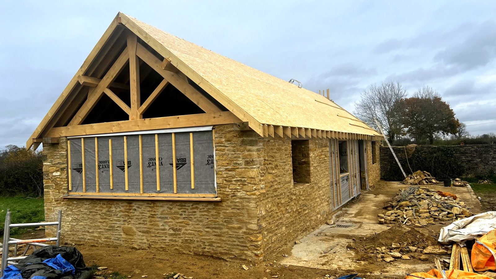 Stone barn with a new boarded roof and an exposed oak gable truss