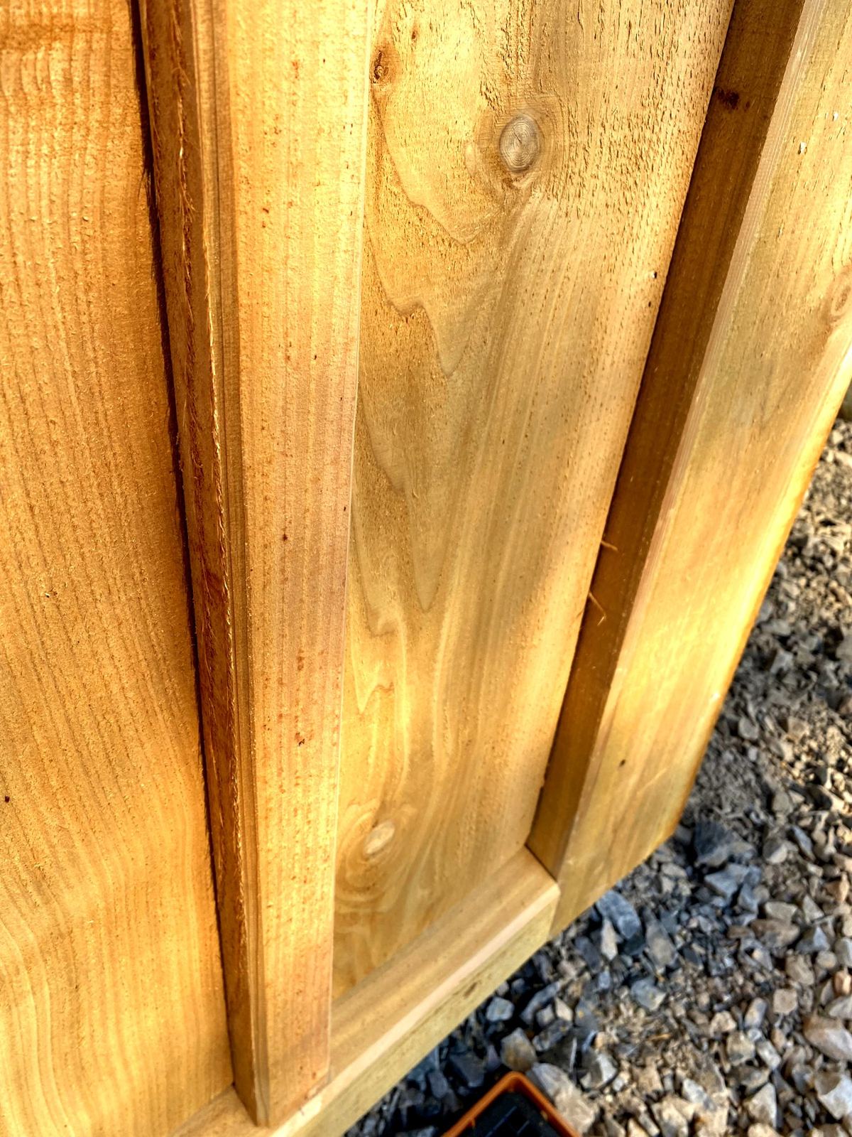 Close-up of a cedar batten over boards, meeting the base rail