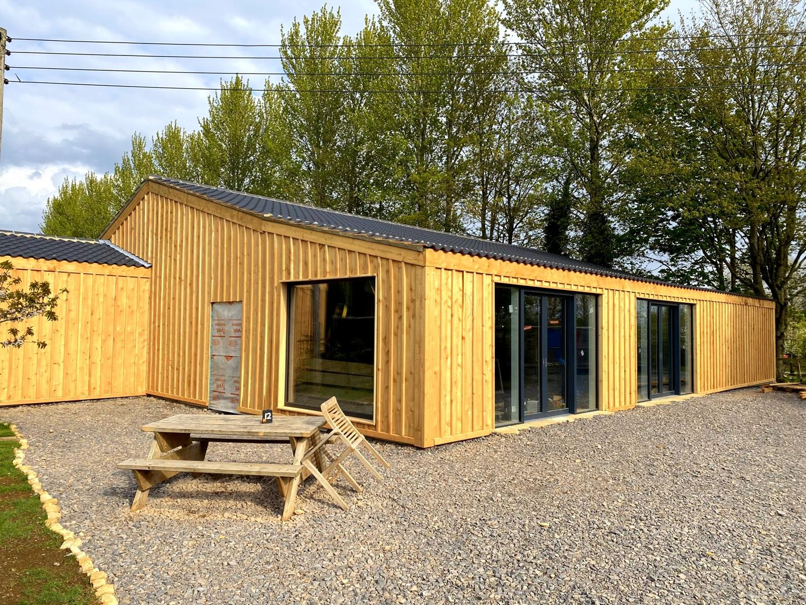The events barn in daylight, with a picnic table on the gravel in front