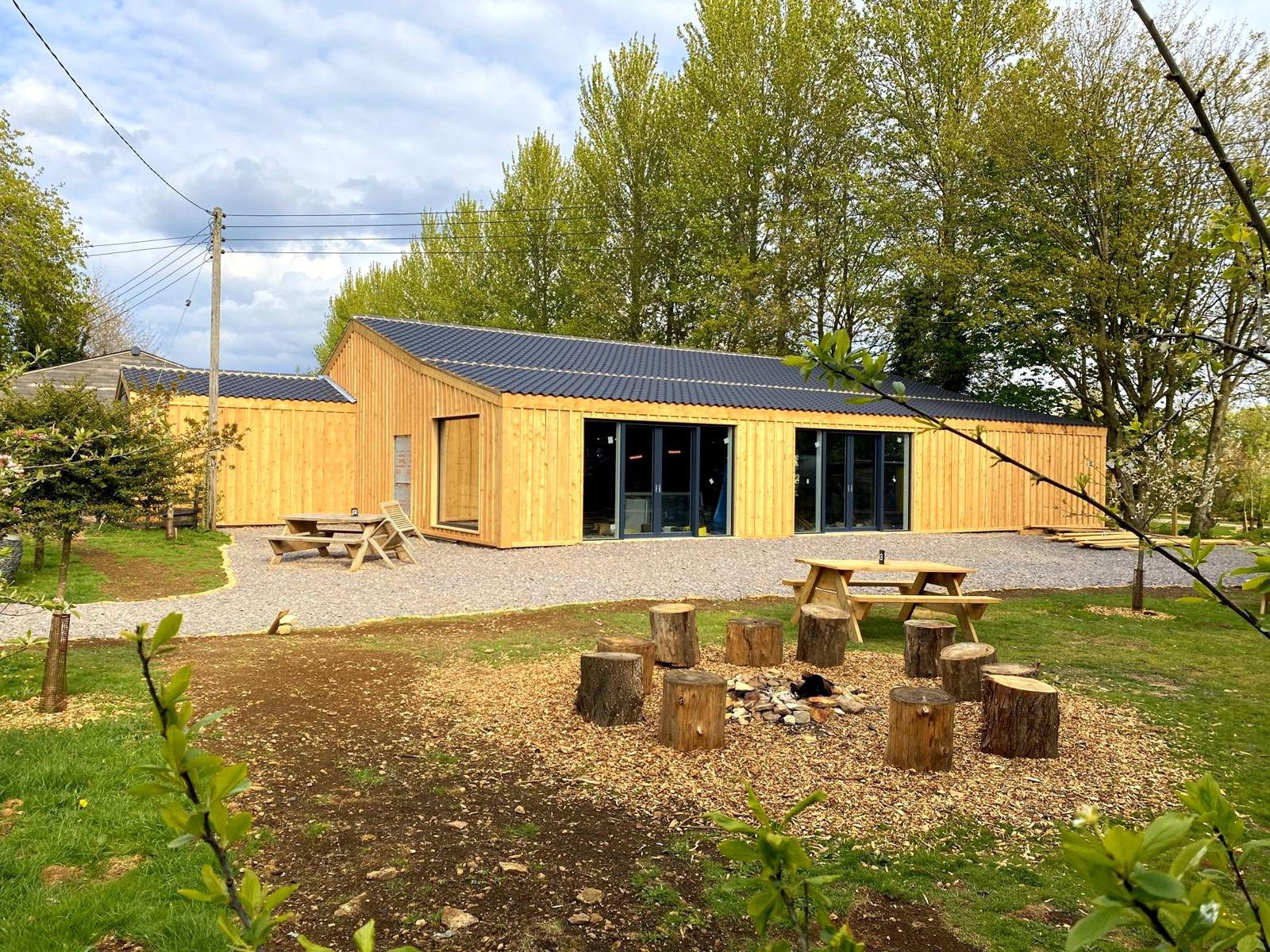 The events barn in daylight, with a fire pit and picnic tables in front