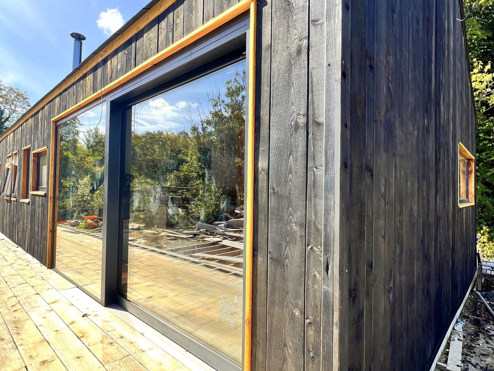 Our family home in a disused quarry: charred vertical cladding, a large picture window and a timber deck