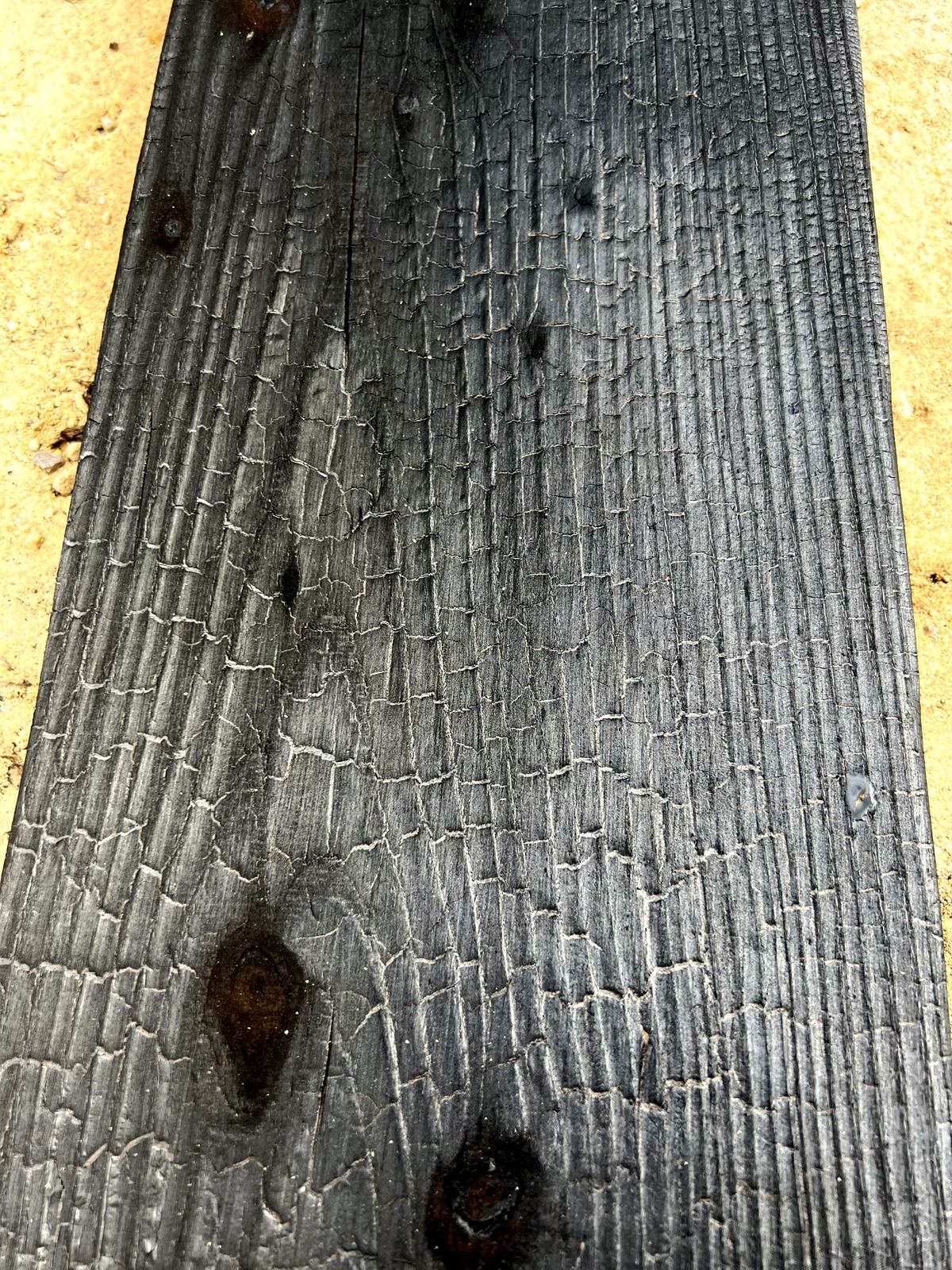 Close-up of a charred board with a crackled surface