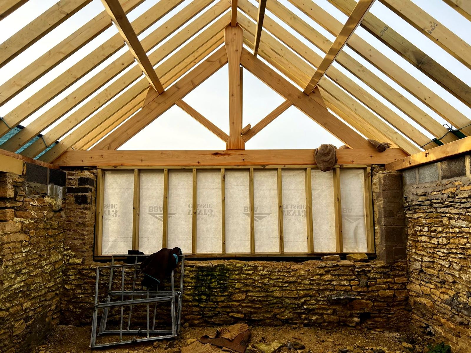 Reproduced king-post truss above a framed gable in the rebuilt stone barn