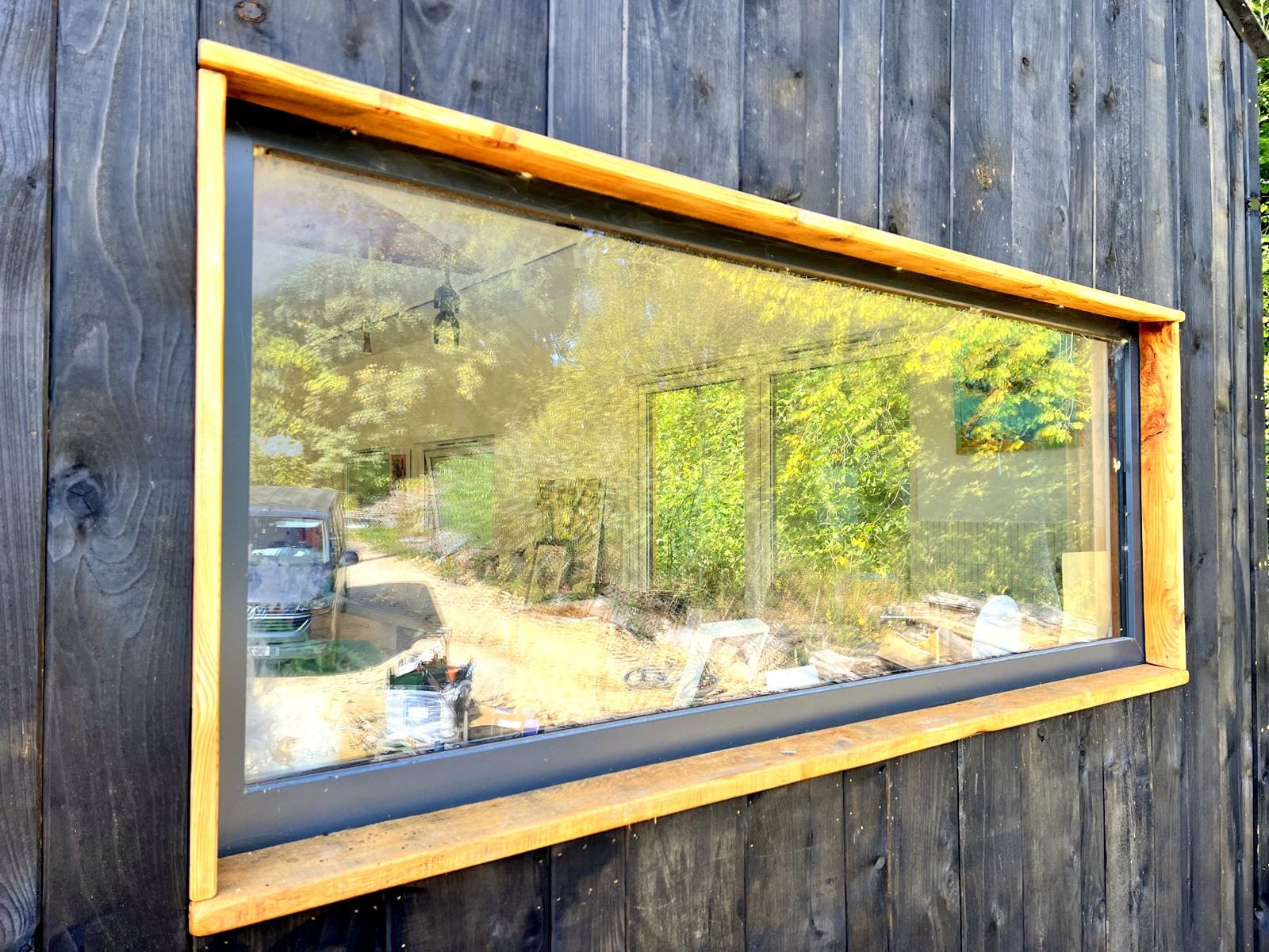 Picture window with a cedar surround set in charred black cladding