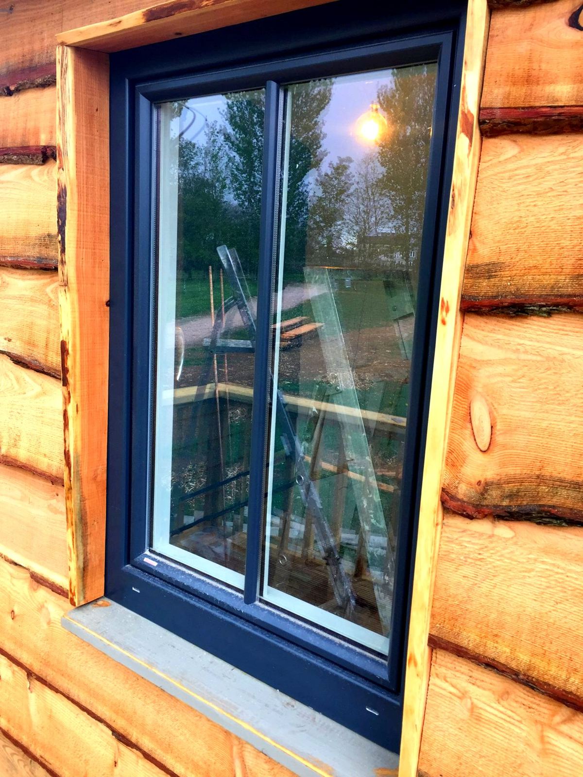 Window with live-edge timber reveals in waney-edge cladding